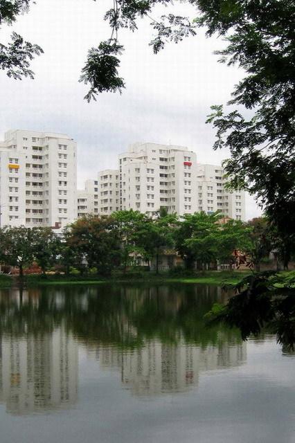View of Udita apartment blocks from artificial lake on central greens