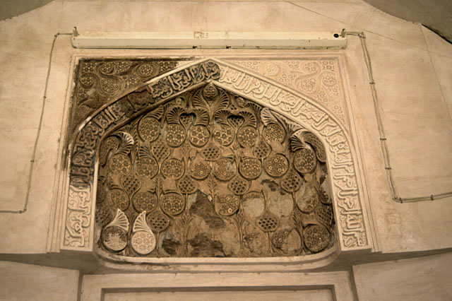 Detail view of the decorative stucco arch on the mihrab located right of center