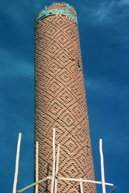 Detail of minaret, showing top with remnants of tile inscriptive band