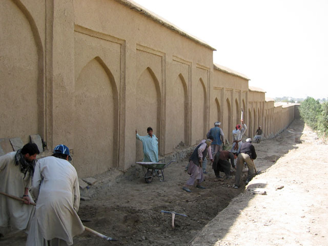 Southern garden wall, after restoration, view looking west with workers digging trench along wall