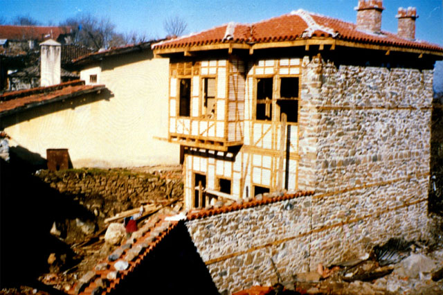 Exterior view showing stone walls and clay roof