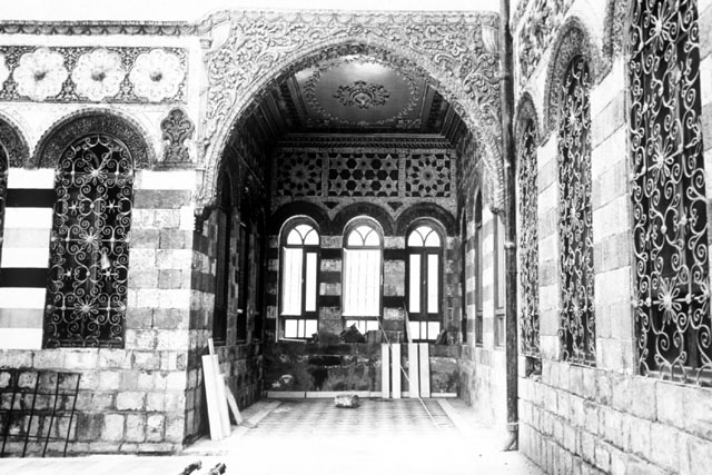 Anbar School Restoration - Interior view showing intricate plaster carving, iron grates and stone work