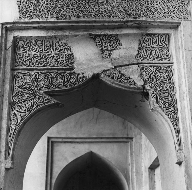 Detail view of the carved stucco inscription and decoration above a doorway
