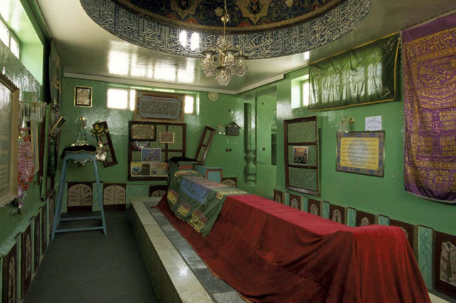 Interior view of Asheq Tomb, showing modern dome chamber with fragments of the original timber enclosure displayed on walls