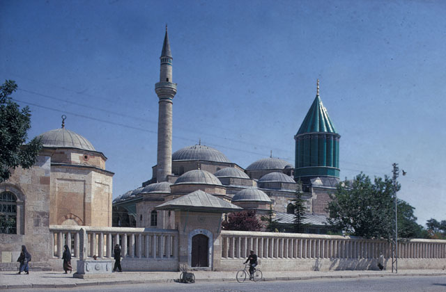 General view from southwest, showing precinct walls with Hamusan Gate (Gate of Sealed Lips) leading to the cemetery across the street, The domed tomb of Hürrem Pasa appears to the left of the gate, while the domes of the shrine-mosque ensemble are seen behind the gate
