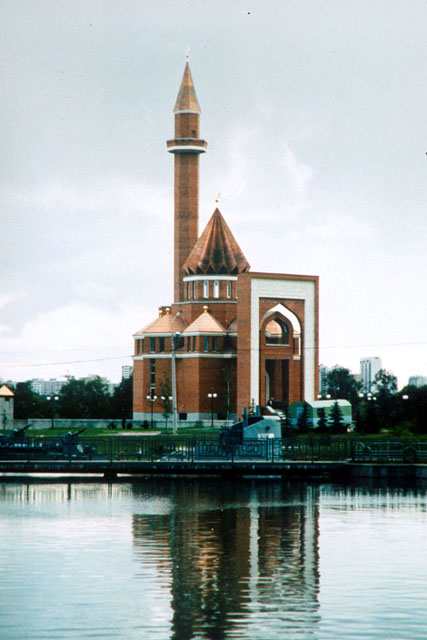 Exterior view showing abstracted pishtaq, domed and semi-domed main hall and minaret