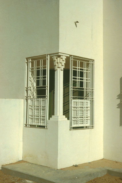 Exterior detail showing treatment of corner space with columns and iron grate