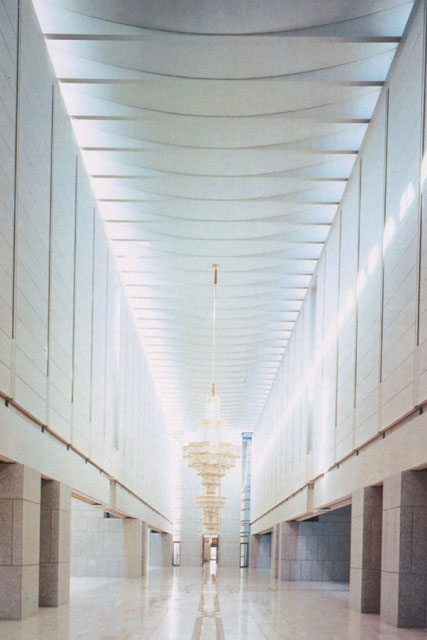 Interior view along long and tall hall to entrance
