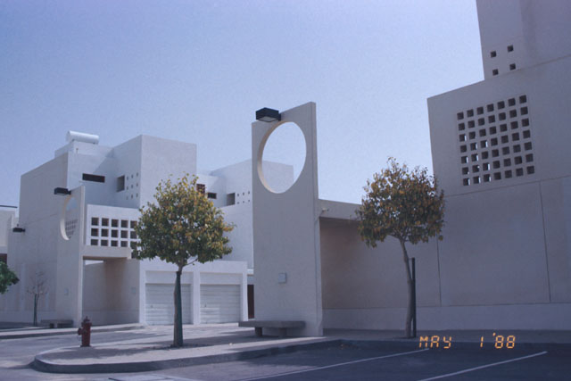 Exterior view showing concrete façade, car-ports and seating