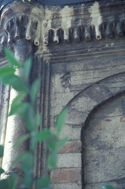 Exterior detail from tomb showing blind window with red and white stone arch,  engaged column and stalactite cornice