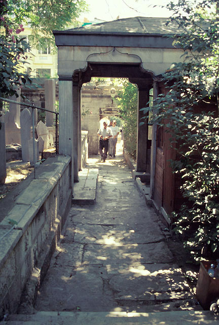 View looking south towards precinct gate on Yeniçeriler Street, showing pathway covered by tomb portico with eighteenth century cemetery to its left