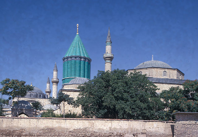 General view from east showing green dome marking Rumi's grave, with mosque minaret and dome of <i>semahane</i> seen to its right. The dome and two minarets of the Selimiye Mosque appear in the left background