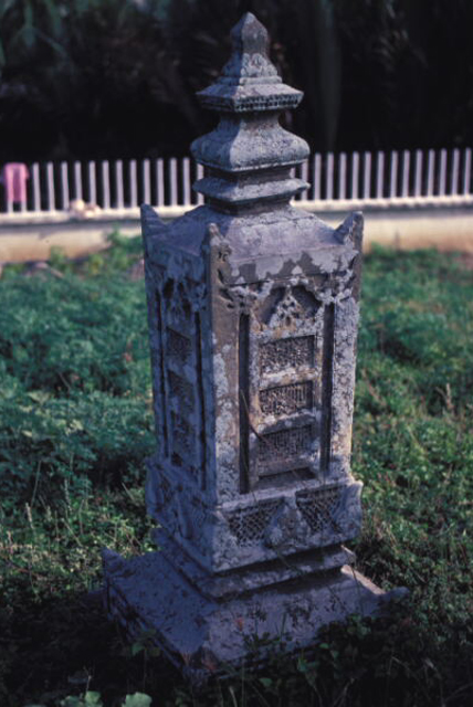 Gravestone of Sultan Johan Syah in the batu aceh form showing a ladder framing of Koranic inscription on the body, the distinctly Achenese lotus overlaying the spider-web pattern at base of body