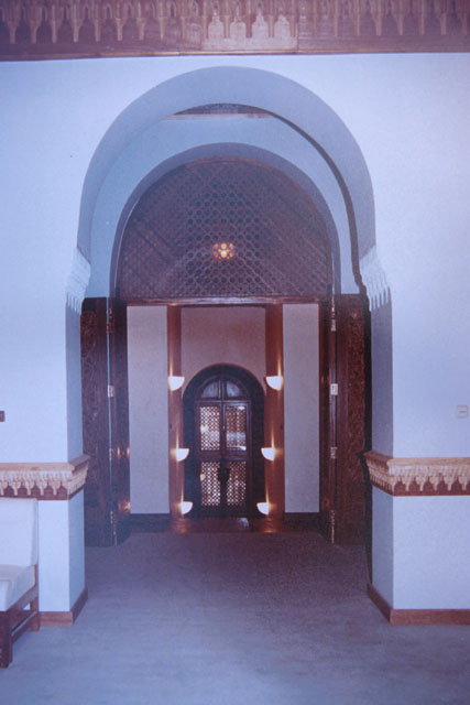 Interior detail showing entrance set in horseshoe arch and topped with wooden lattice work