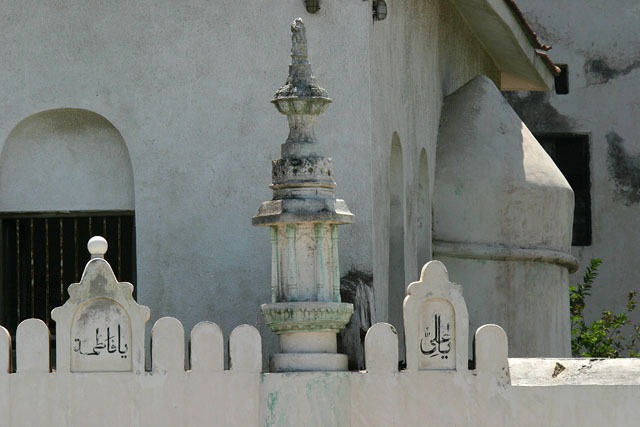 Detail view of exterior wall with round topped crenellations and capitals