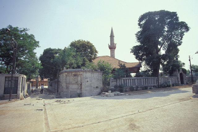 General view from northeast showing precinct walls and the small street that separates the mosque from its cemetery.  The fountain at the corner of the precinct was added in 1819 by Dervis Pasa, the rectangular structure across from it is one of the two open sabils built with the mosque