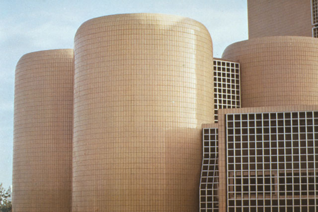Exterior detail showing tiled cylindrical tower and glazed rectilinear building