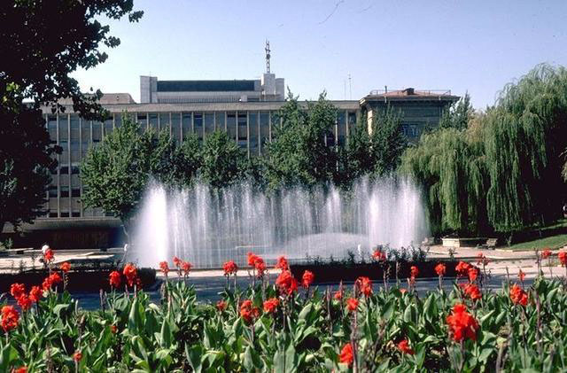 Exterior view of fountain, garden and buildings in background