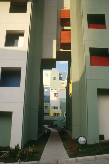 Exterior view between buildings showing painted modular façades