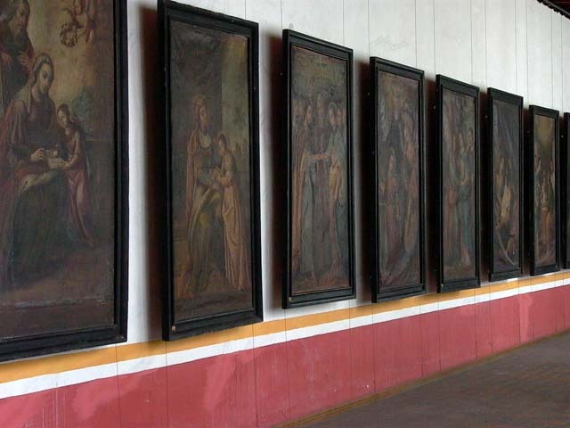 Interior view of paintings hung along wall