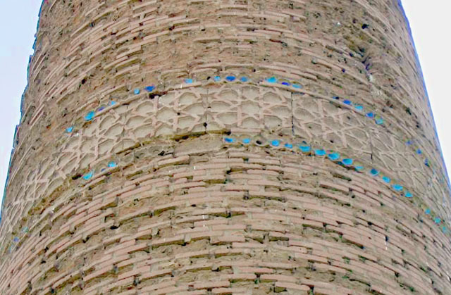 Detail of minaret showing decorative band with red and blue tiles, view from east