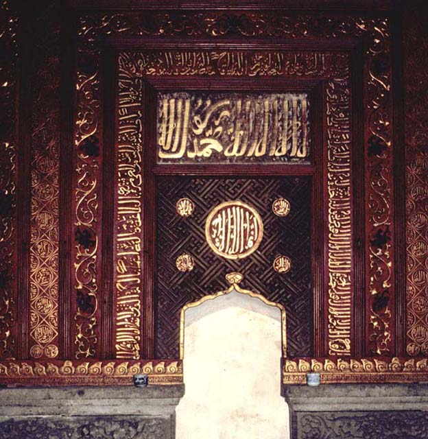 Detail of woodwork and gilded religious inscription on mihrab