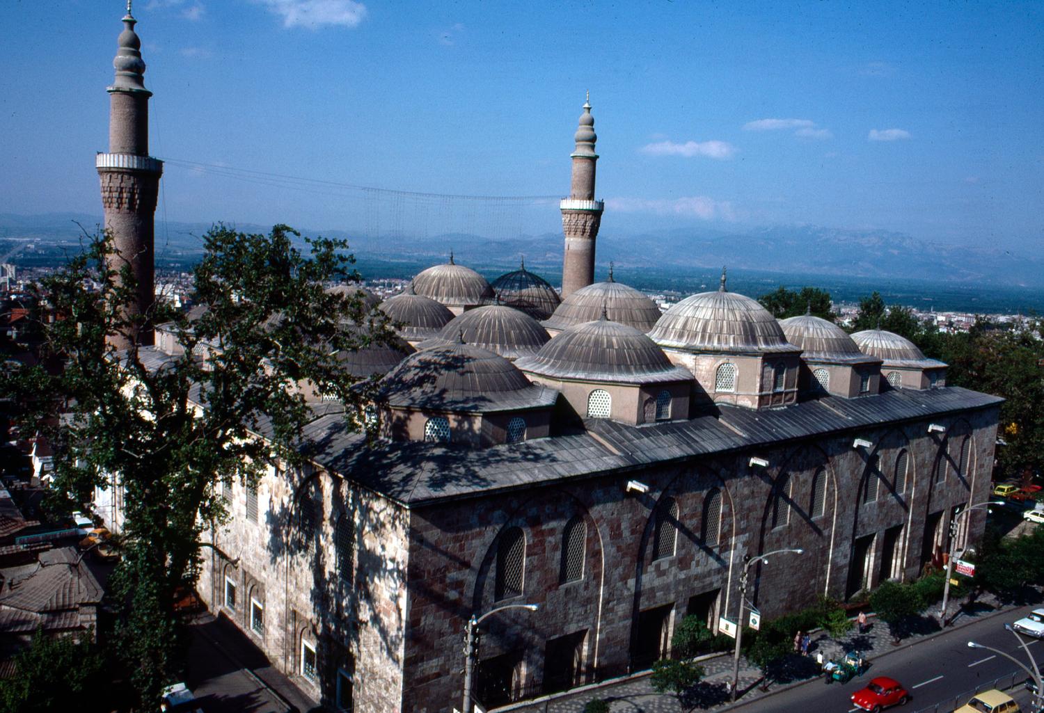 View of the southern façade and the roof with its twenty domes, with the Atatürk street in front and the Bursa plains in the distance
