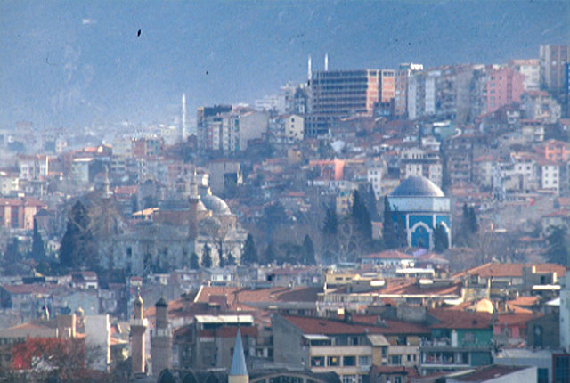 View of the complex in the city; among cypresses on a hill, the mosque (left) and the mausoleum