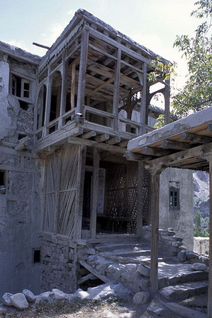 Khaplu Palace Restoration - Exterior view from northeast, showing wooden entry porch with balcony above, before restoration