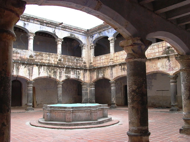 Exterior view of cloister courtyard showing two stories of porticos and central fountain