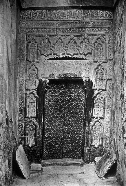 Internal view of entrance door with copper panels showing marble carvings