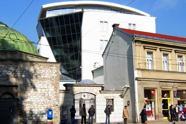 Exterior view from south, showing gateway to courtyard, with modern building of Bosniak Institute seen behind