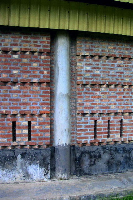 Exterior detail; concrete column embedded in brick wall