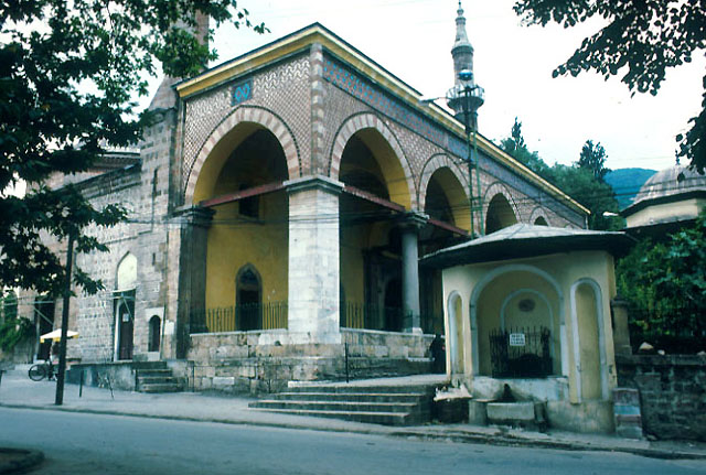 Exterior view of mosque from northeast showing entrance portico and a fountain flanking street entrance