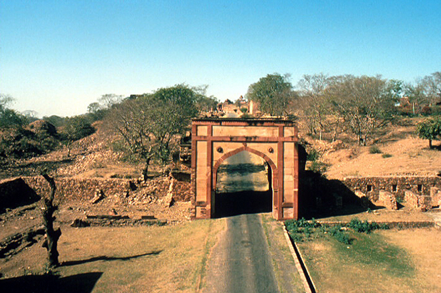 Exterior view of arched gateway toward southwest framing road