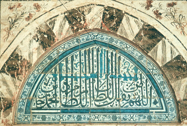 Exterior detail from portico, showing tiled tympanum of window with prayers in Arabic mentioning the founder of the mosque