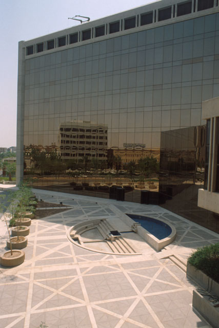 Exterior view showing glazed façade mirroring piazza and neighboring buildings