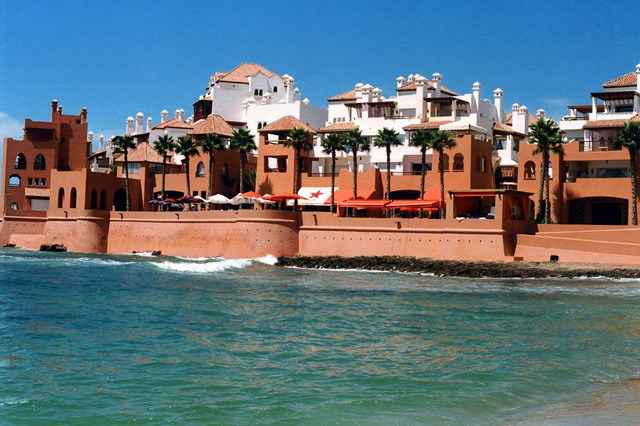 Bouznika Kasbah - General view from Bouznika beach, showing sea walls and seaside terrace with palm trees