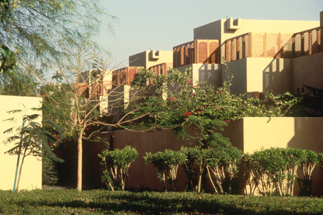 Exterior view showing stepped pattern of brick wall and concrete façades with wooden screens