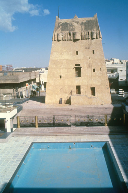 Exterior view of fortified tower beside common pool