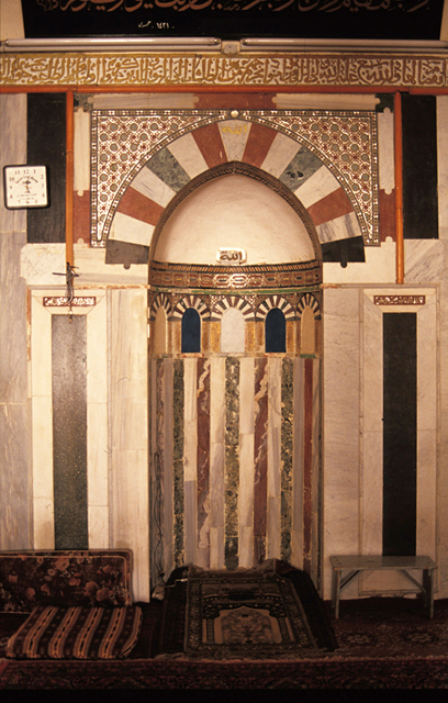 Interior view; mihrab niche with polychrome stone revetment and gilt inscriptive band