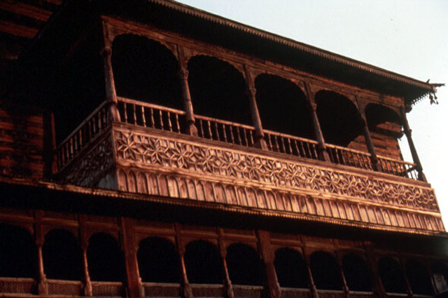 Detail, upper balcony showing its later date by the quality of wood used