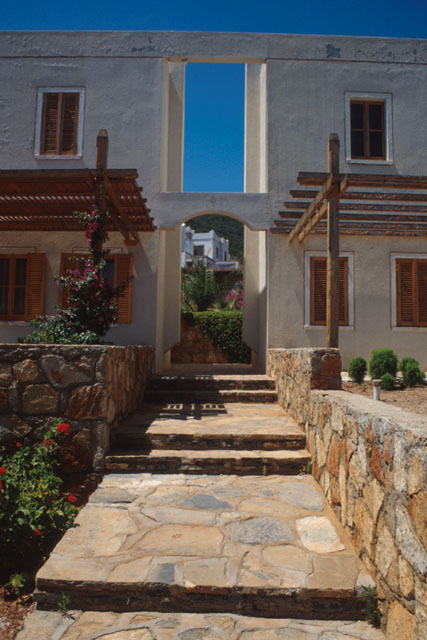 Exterior view showing stone path to whitewashed façade with wood detailing