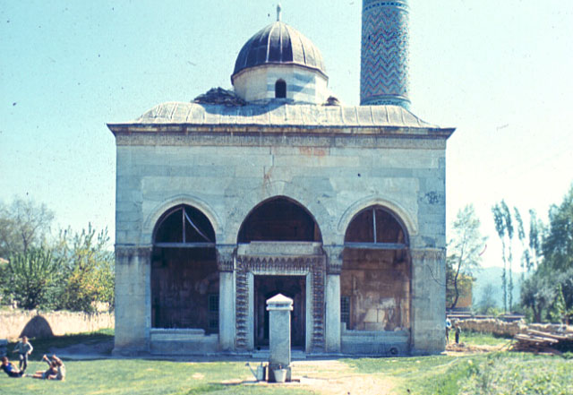 Exterior view  of portico before restoration showing mosque with collapsed dome and remains of the broken marble balustrades on either side of the entry