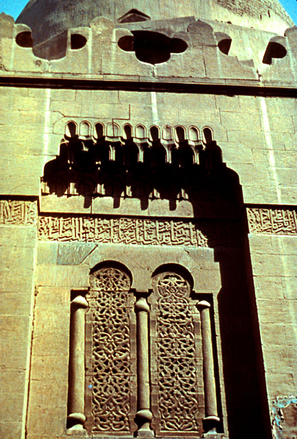 Detail view of the portal showing windows with carved wooden grille