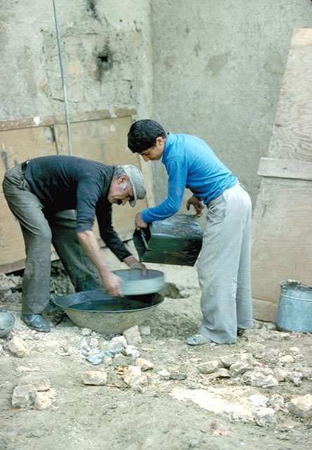 Workers readying a mud mixture for surface rendering
