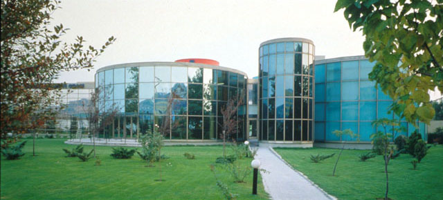Exterior view, showing curved façade's mirrored glazing