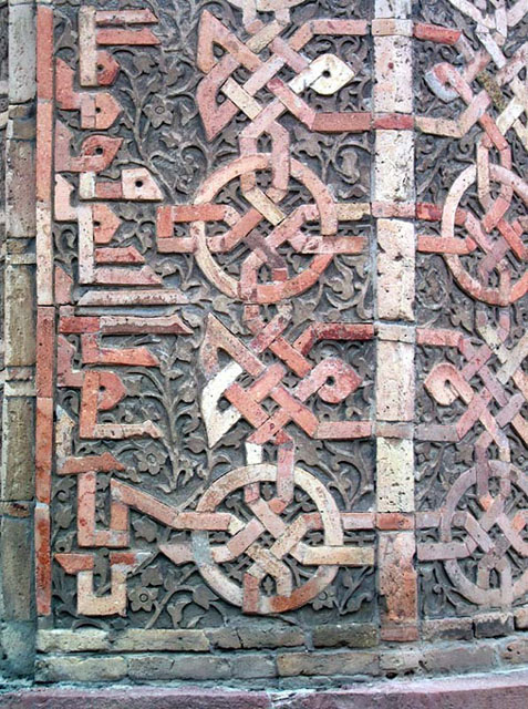 Mömina Xatun Türbasi - Exterior detail showing brickwork with geometric motifs and Kufic inscription