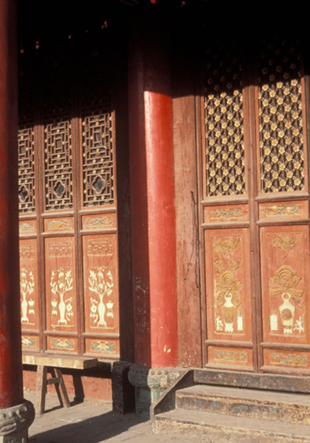 Latticed and lacquered panels of prayer hall verandah with columns and stone bases