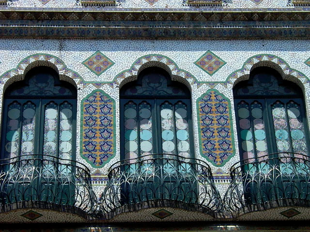 Exterior detail view of balconies with trefoil arched openings surrounded by tilework